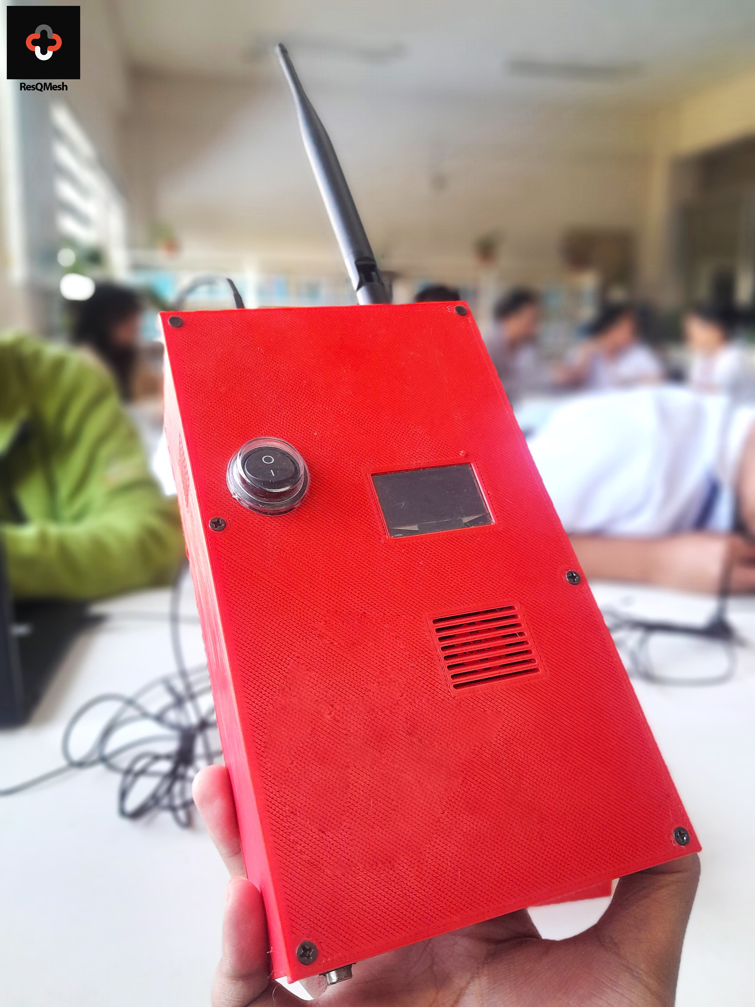 Red ResQMesh mesh node prototype with antenna, power switch, OLED display, and speaker enclosure